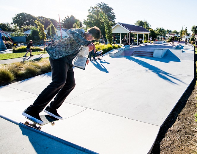A skater balanced at the top a quater pipe about to roll down