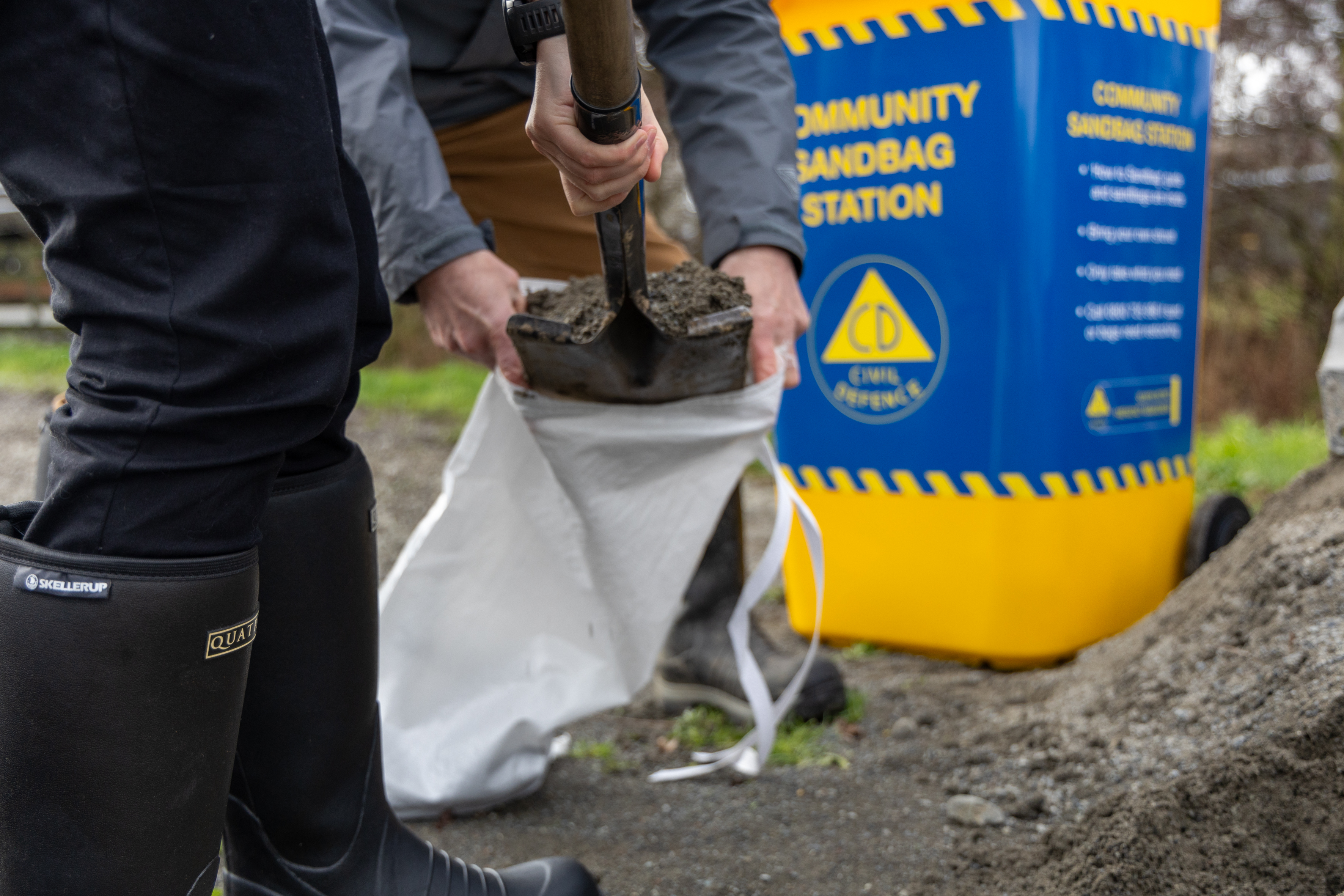 Two people making sandbags to prepare for flooding